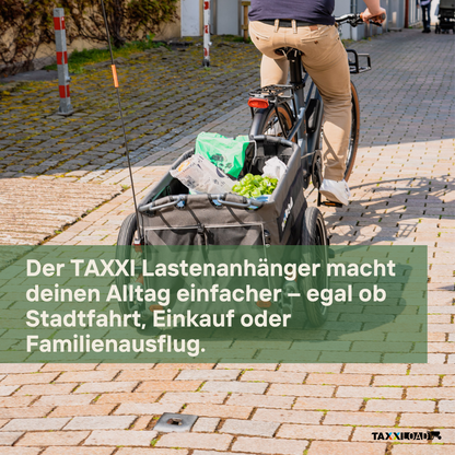 Lastenanhänger LOAD heavy am Fahrrad mit Einkaufstaschen auf gepflastertem Weg für Stadtfahrten und Familienausflüge